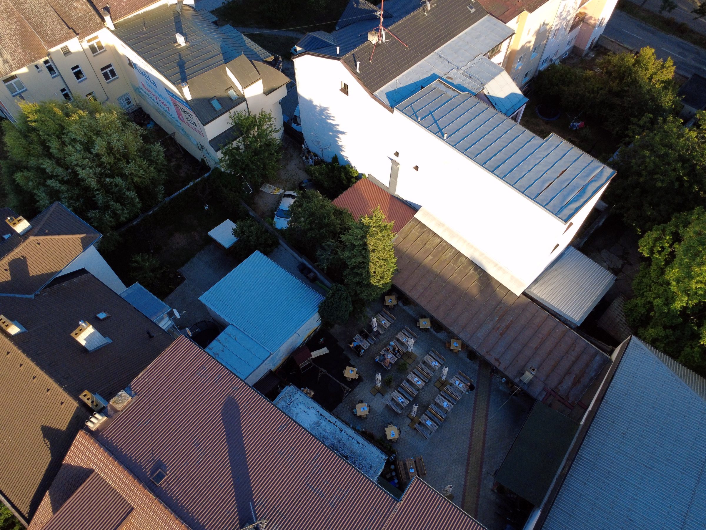 Letecký záběr střech v centru města se zahradní restaurací