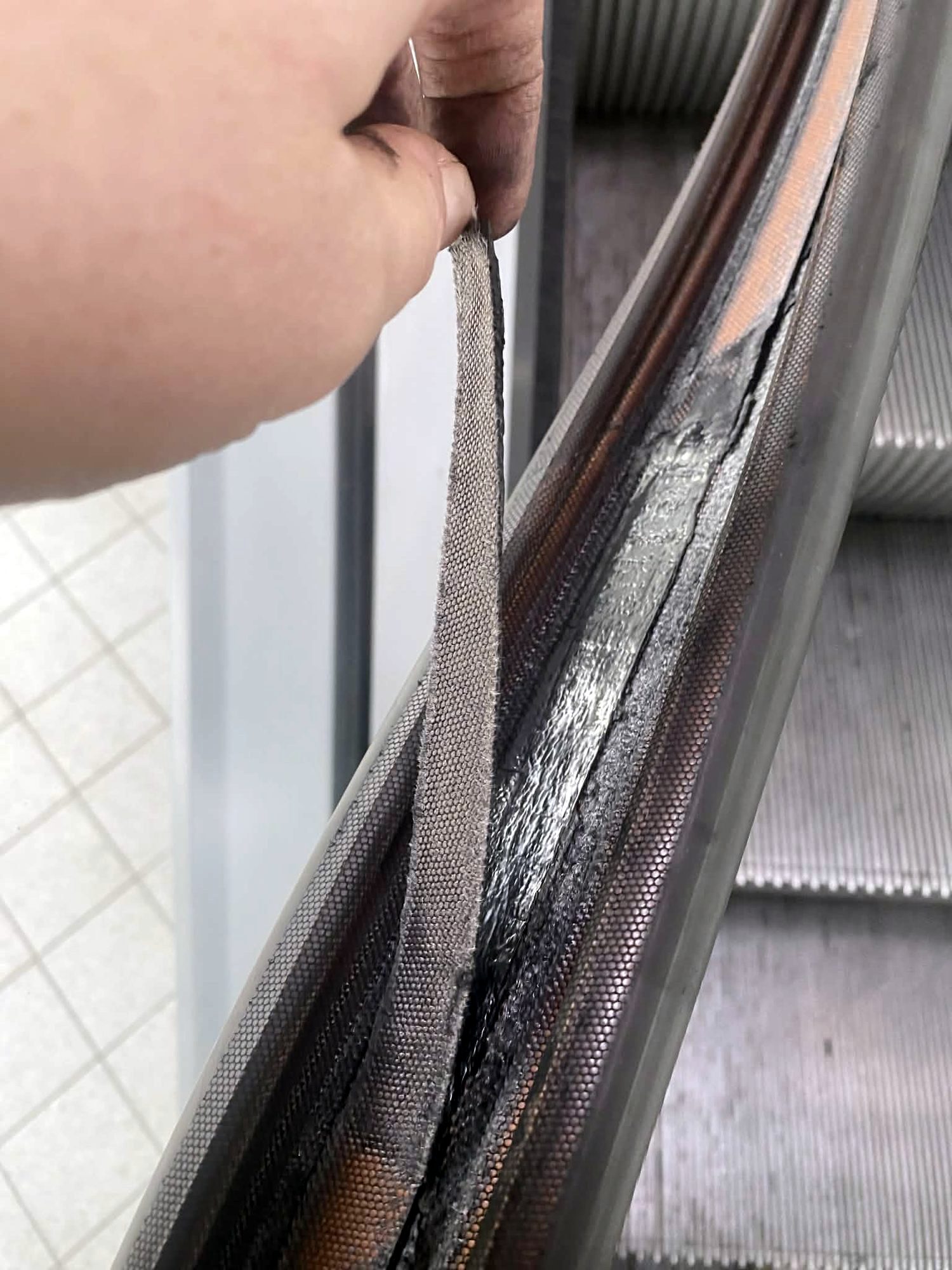 Detail madla eskalátoru v ruce montéra